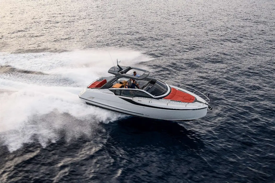 A sleek motorboat speeds across the water with three people onboard, creating waves in a tranquil marine environment.
